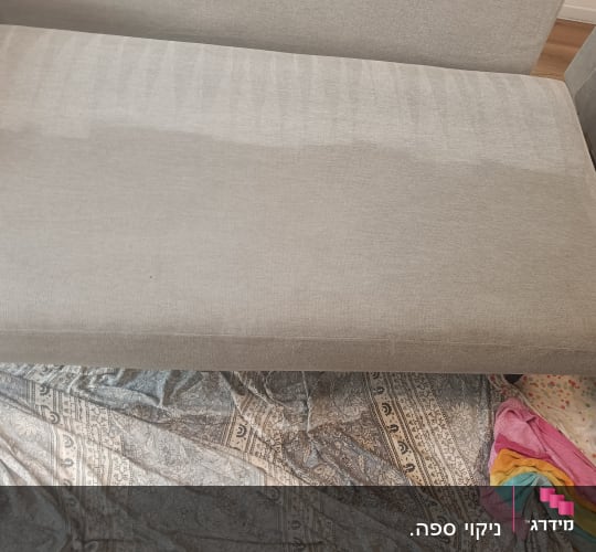 כרית ספה אפורה עם סימני ניקוי על בד מגן